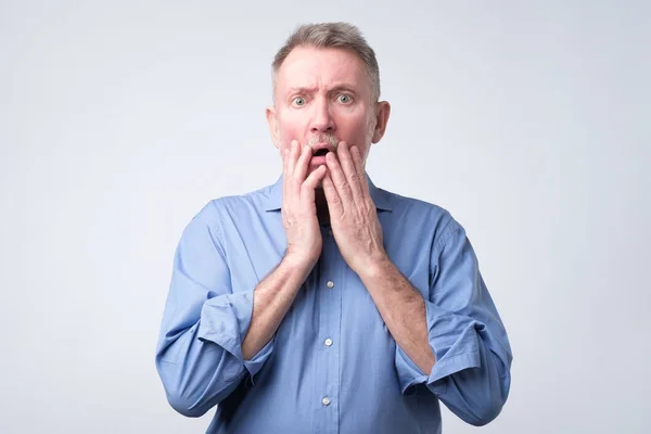 Senior european man with scared and anxious expression, bites finger nails — Stock Photo, Image