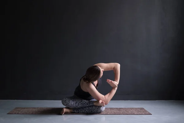Womanl uit te werken, twisted doen yoga oefening op vloer agnistambhasana — Stockfoto