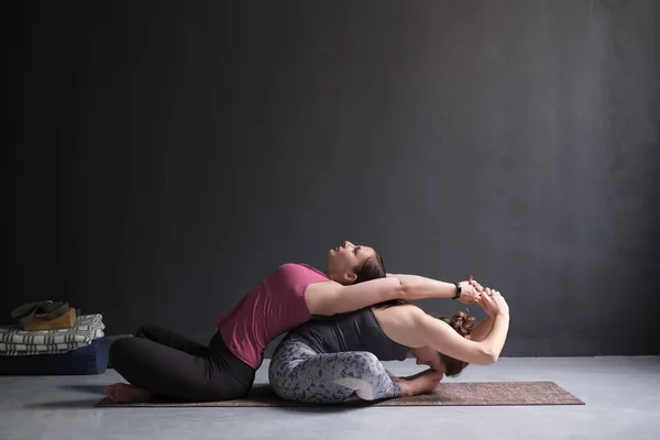 Två kvinna gör yoga grupp supta baddha konasana. — Stockfoto