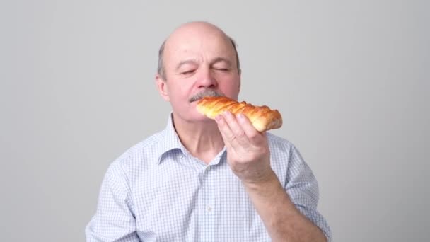 Senior satisfied man smelling pie or cake — Stock Video
