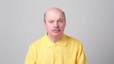 Olgun beyaz adam mavi gömlek sessizlik jest yapma.