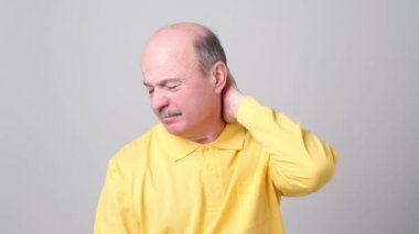 Kapalı gözlerle onun boyun ağrın dokunmadan sarı tshirt olgun adam.