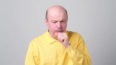 Olgun Latin asıllı adam sarı tişört adam öksürük olmak hasta.