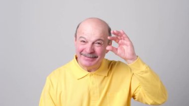 Olgun adam bir şey gösterilen süre mimik ve gülümseyen elleriyle küçük