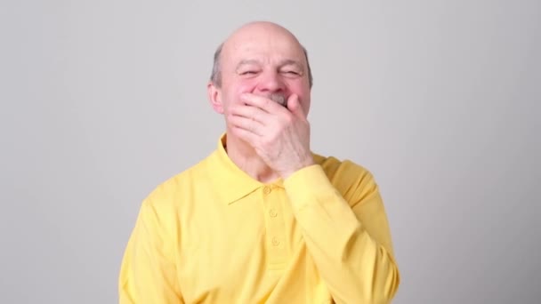 Volwassen man lachen en zijn mond met de hand die betrekking hebben op witte achtergrond. — Stockvideo