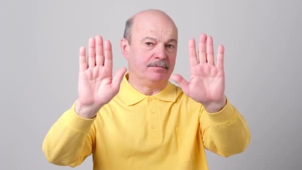 Ontevreden Volwassen Man Weigert Stretching Handen Naar Camera Grijze Achtergrond — Stockvideo