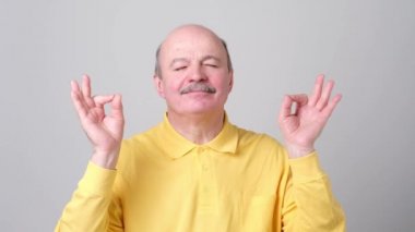 Beyaz tişörtlü konsantre olgun adam zor çalışma günden sonra dinlenmek çalışır