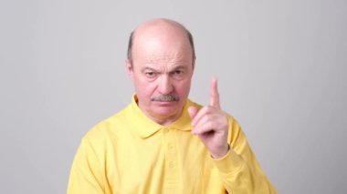 Yukarı katı yakışıklı olgun kel adam bir şey seçmek için yasaklar