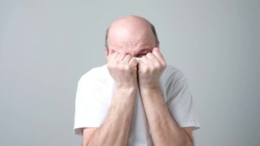 Yüzünü t-shirt tarafından kapsayan ve kameraya gözetleme Avrupa olgun adam