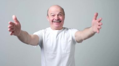 Komuta sizde geniş gülümseyerek el kameraya doğru çekerek beyaz t-shirt.