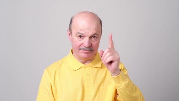 Strict senior man showing index fingers up, giving advice — Stock Video
