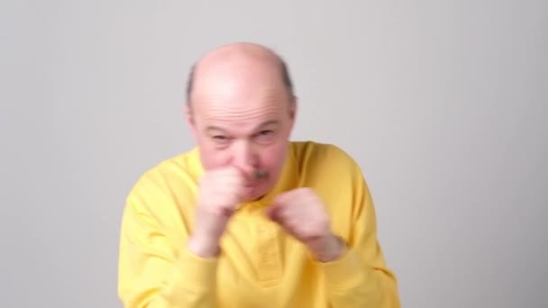 Mature bald man raising fists as defending or fighting, expressing confidence — Stock Video