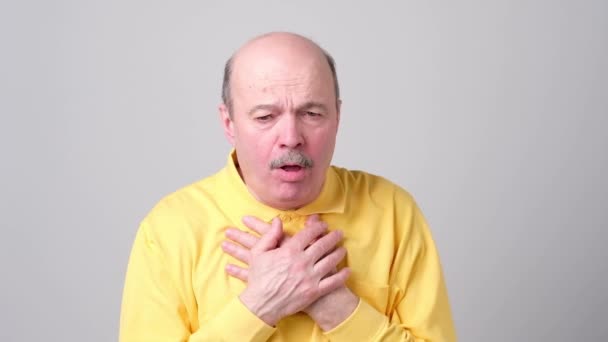 Älterer hispanischer Mann in gelbem T-Shirt Mann hustet krank. — Stockvideo