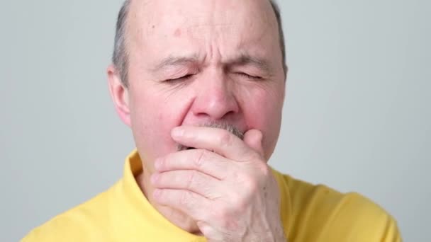 Sleepy man in yellow shirt yawning, morning and wake up — Stock Video