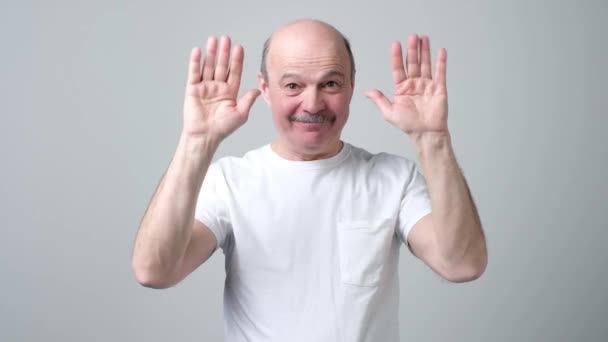 Starszy człowiek łysy mówiąc bye do swoich przyjaciół, machając rękoma. — Wideo stockowe