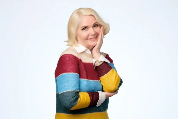Senior mujer caucásica con el pelo rubio en suéter de color sonriendo — Foto de Stock