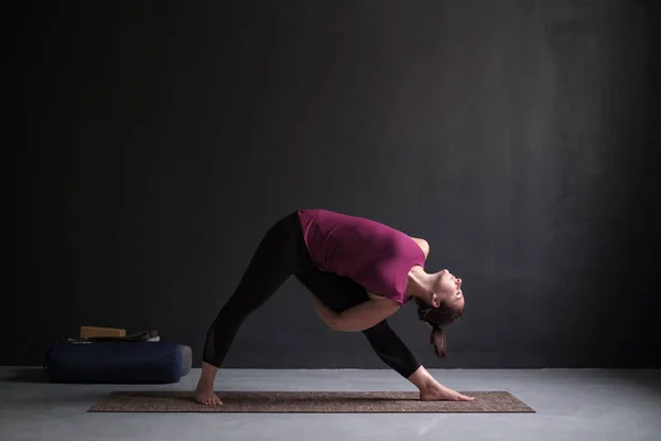 Flicka i Utthita Trikonasana, förlängd triangel pose. — Stockfoto