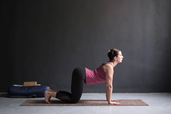 Kvinna som arbetar ut ag gör yoga eller pilates träning. Katt, Marjaryasana — Stockfoto