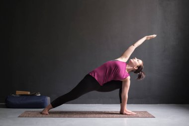 Genişletilmiş yan açı duruş, yapıyor kadın Utthita Parsva Konasana.