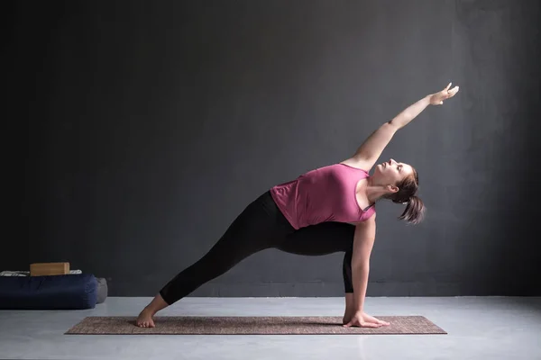 Woman doing Extended Side Angle posture, Utthita Parsva Konasana. — Stock Photo, Image