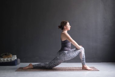 Kadının yapması Hatha yoga asana Anjaneyasana veya izole düşük Hilal hamle poz,