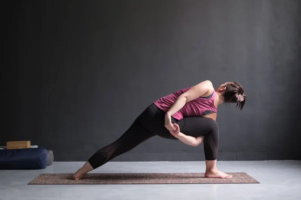 Žena, která dělá rozšířené boční úhel držení těla, Utthita Parsva Konasana ze zadní strany — Stock fotografie