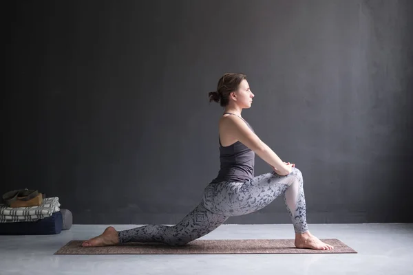 Kvinnan gör Hatha yoga asana Anjaneyasana eller låg crescent lunge pose isolerade, — Stockfoto