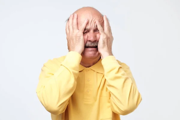 Ein besorgter älterer Mann drückt panisch die Hände an den Kopf. Schrei vor schlechten Nachrichten. — Stockfoto