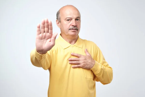 Retrato de un hombre mayor serio mostrando gesto de alto con la palma de su mano —  Fotos de Stock
