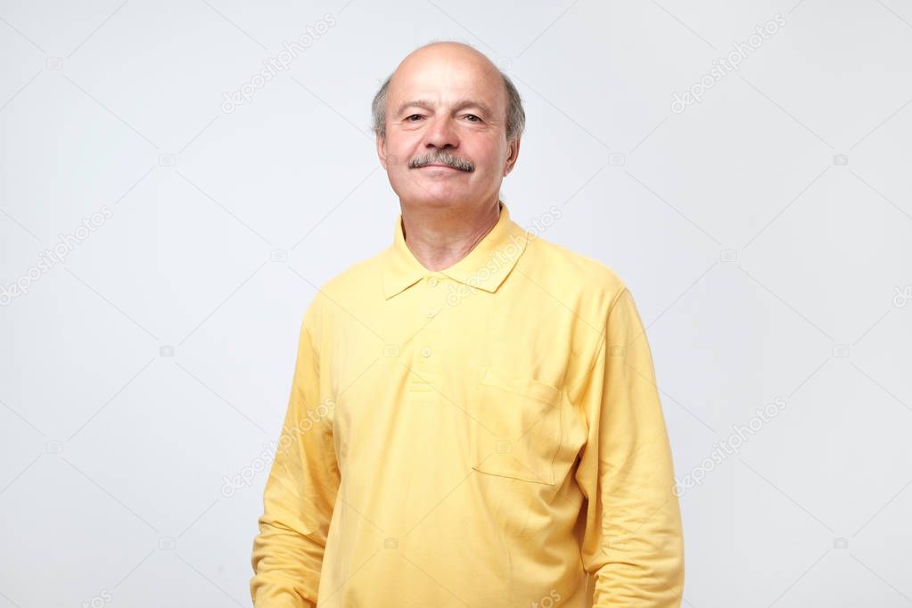 Confident hispanic mature man in shirt looking at camera and smiling