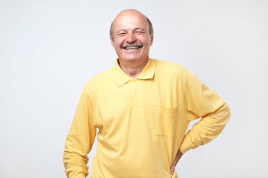 Beyaz arka plan üzerinde kameraya bakarak gülen olgun yetişkin adam.