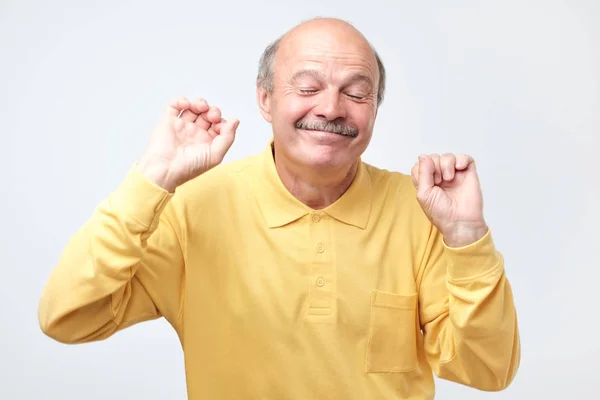 Älterer glücklicher Mann bewegt sich tanzend über weißem Hintergrund. — Stockfoto