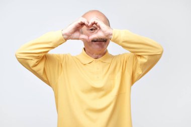 Ellerini kalbinde öpüşürken bıyıklı olgun adam.