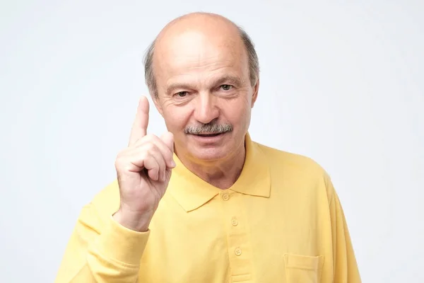 Strict mature man showing index fingers up, giving advice — Stock Photo, Image