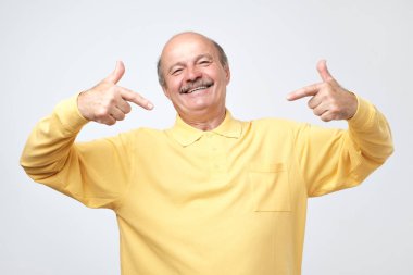 Yüzünde gülümseme ile kendinden emin görünüyorsun, kendini parmakları ile işaret kel adam