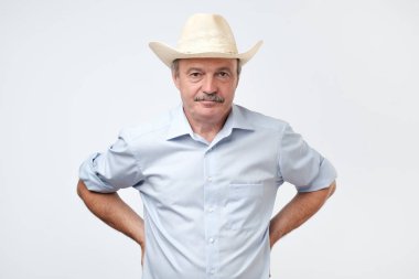 Olgun adam Studio giyen kovboy. Güven ile kameraya bakıyor