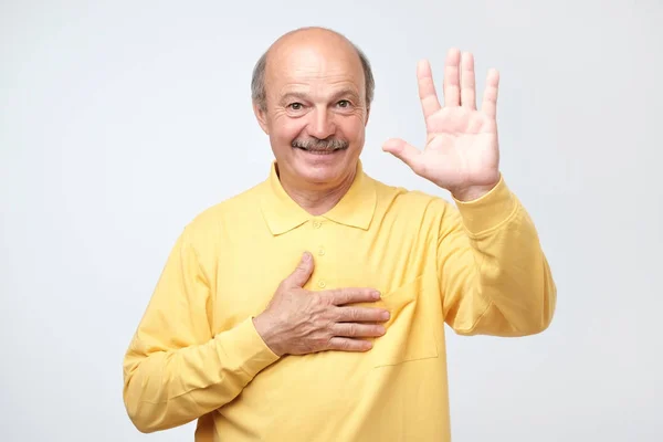 Senior Mann hebt Handfläche und hält Hand auf Brust und verspricht mir Ehrlichkeit — Stockfoto