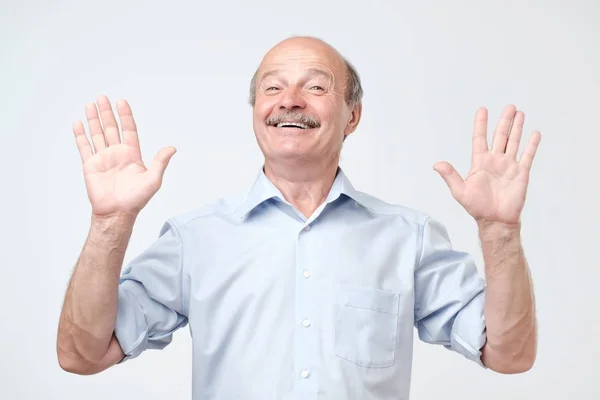 Chico alegre levanta las manos como muestra de no estar involucrado, tiene mirada feliz —  Fotos de Stock