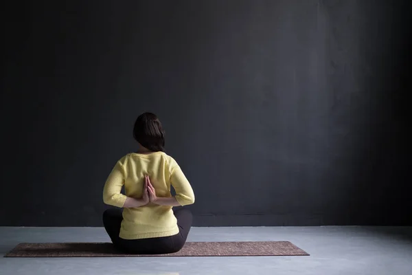Vista posterior de la mujer madura sentada en postura de yoga —  Fotos de Stock
