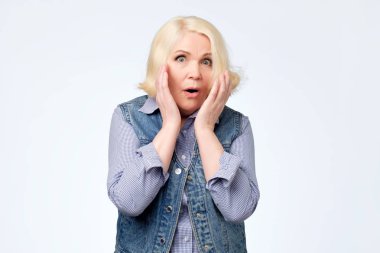 Kadın kıdemli mutlu ve Not tutan yanakları el ile.