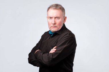 katlanmış ellerle kameraya güven ile seyir siyah gömlekli yaşlı adam