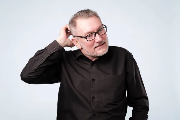 Hombre europeo con camisa negra y gafas pensando en sus problemas . — Foto de Stock