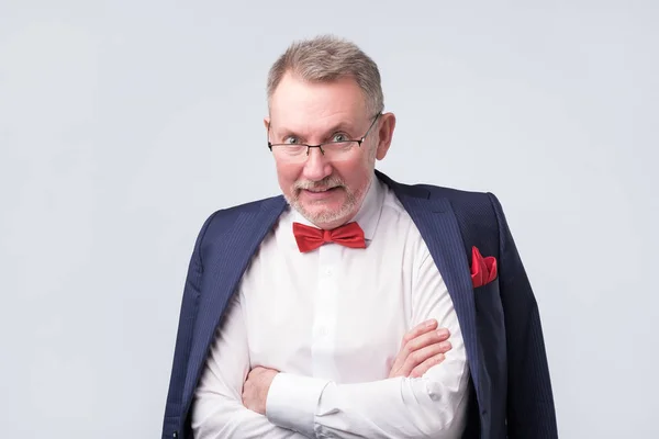 Hombre mayor con anteojos y traje azul sonriendo calurosamente y confiado . — Foto de Stock