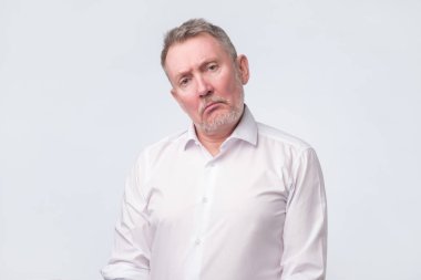 Eski komuta sizde ciddi ve üzücü bir ifade ile Beyaz gömlekli.