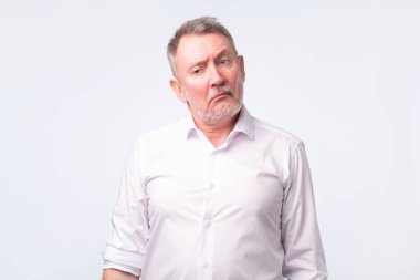 Eski komuta sizde ciddi ve üzücü bir ifade ile Beyaz gömlekli.