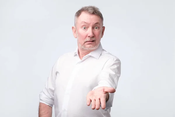 Enojado hombre mayor en camisa blanca mirando a la cámara y acusando . — Foto de Stock