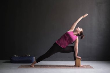 Genişletilmiş yan açı duruş, yapıyor kadın Utthita Parsva Konasana.