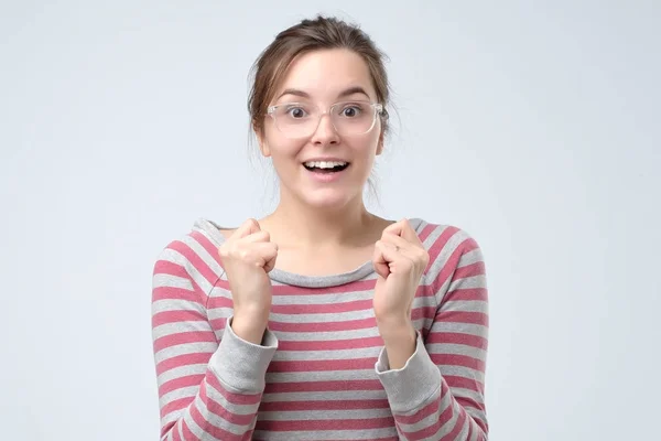 Счастливая молодая женщина держит кулаки, чувствуя удачу — стоковое фото
