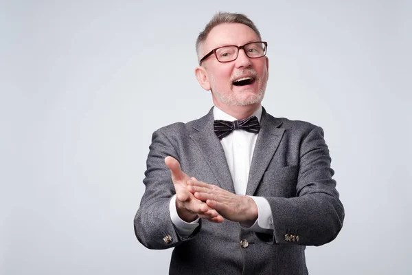 Hombre mayor guapo en gafas y traje aplaudiendo — Foto de Stock