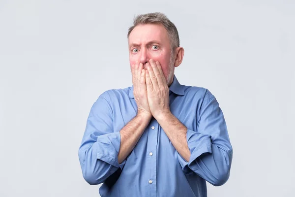 Senior man heeft betrekking op mond en kijkt wanhopig — Stockfoto